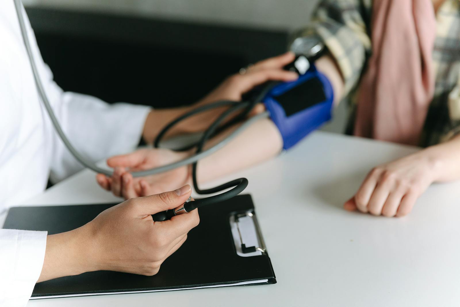 Doctor taking pulse with stethoscope checking health