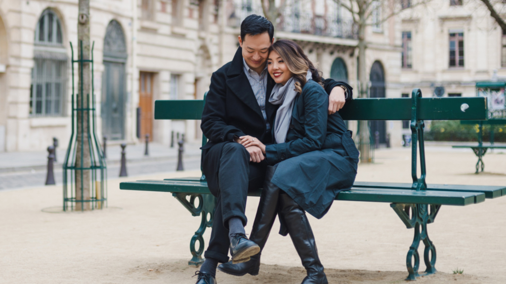 Close and connected couple cuddling on a bench in Paris.