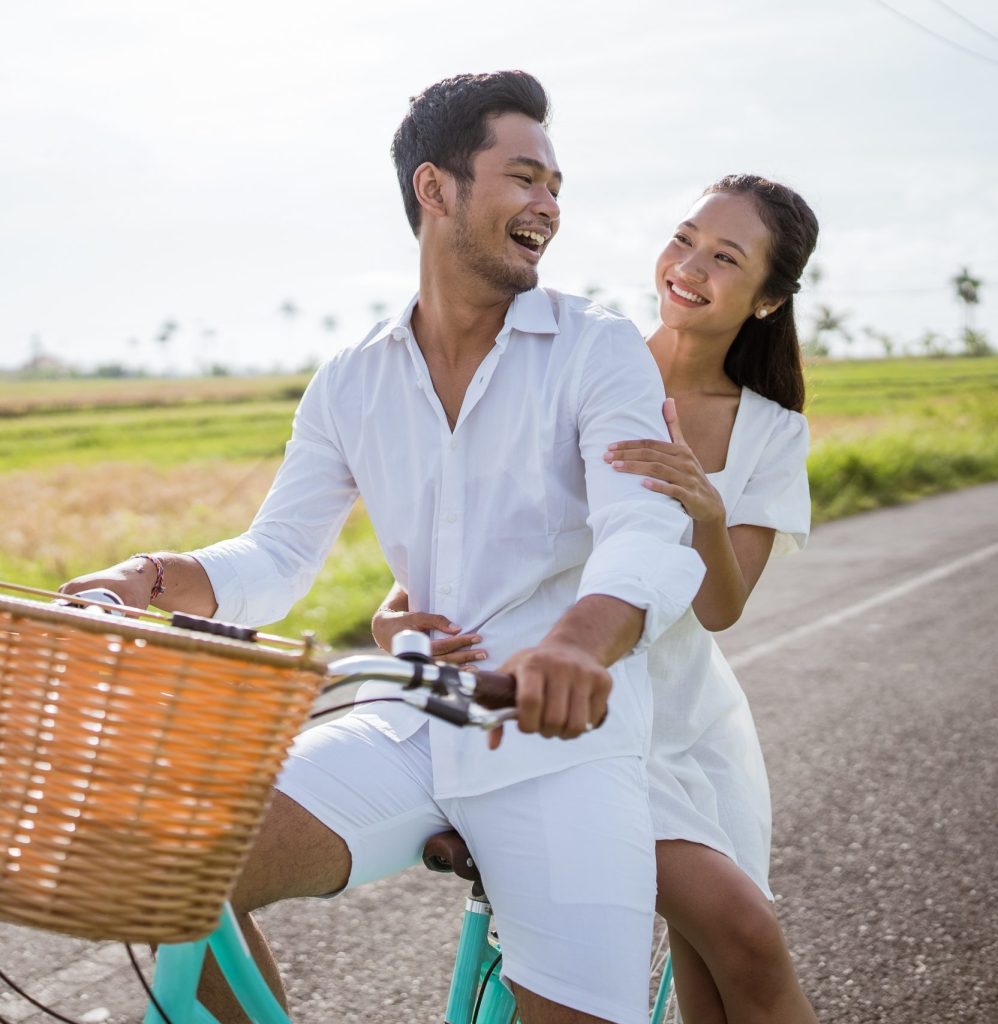 Happy duo on a bicycle, enjoying a connecting activity as a couple.