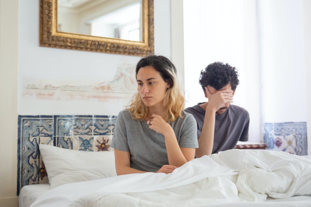 Couple sitting in bed distant and frustrated. Balancing Independence and Emotional Connection