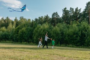 Couple and child happily playing with a kite in a park. 5 Little Known Facts about Attachment