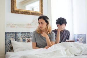 Couple on the bed ignoring each other and how to avoid it