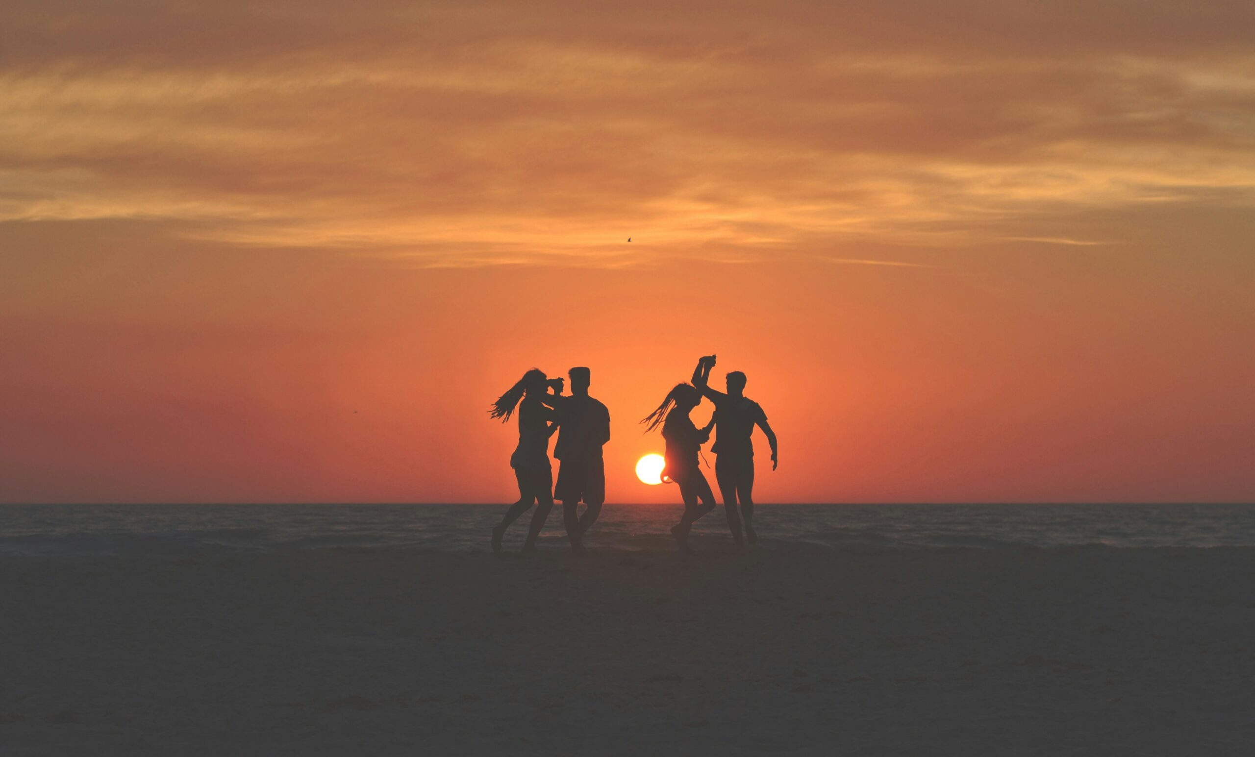 Two couples dancing at a beach in front of a sunset. It’s really not that hard.