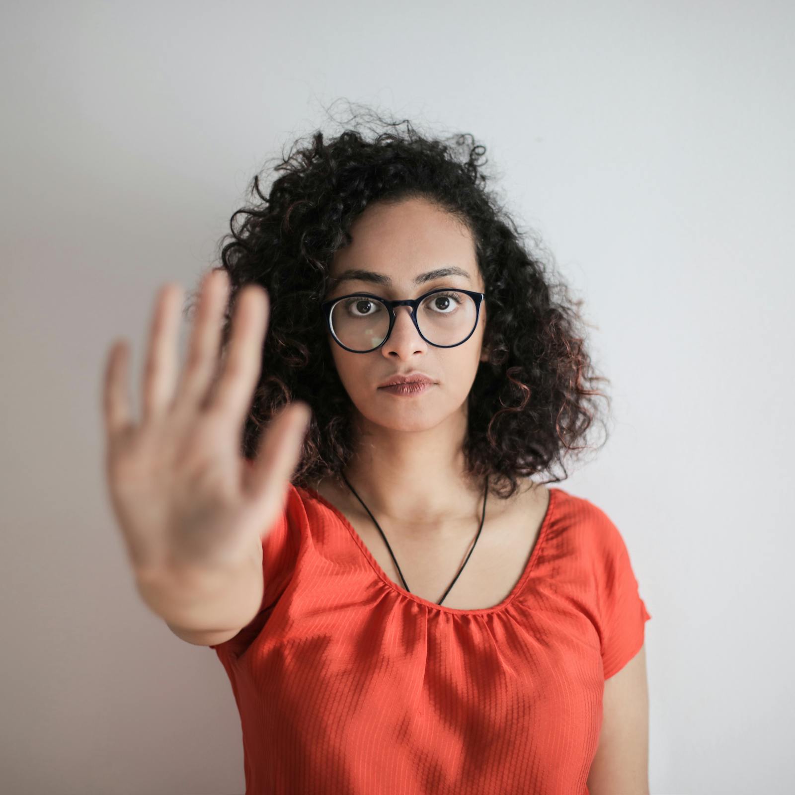 Woman putting hand out in stop gesture to break pattern