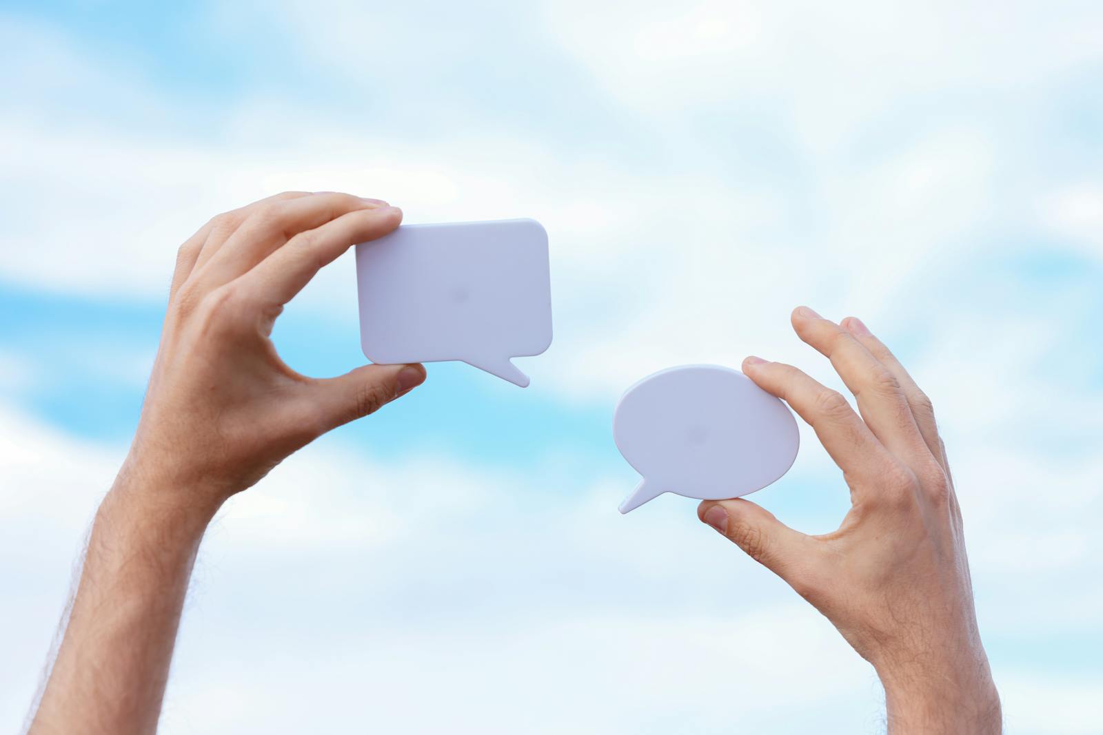 Two speech bubble paper cutouts representing communication and dialogue