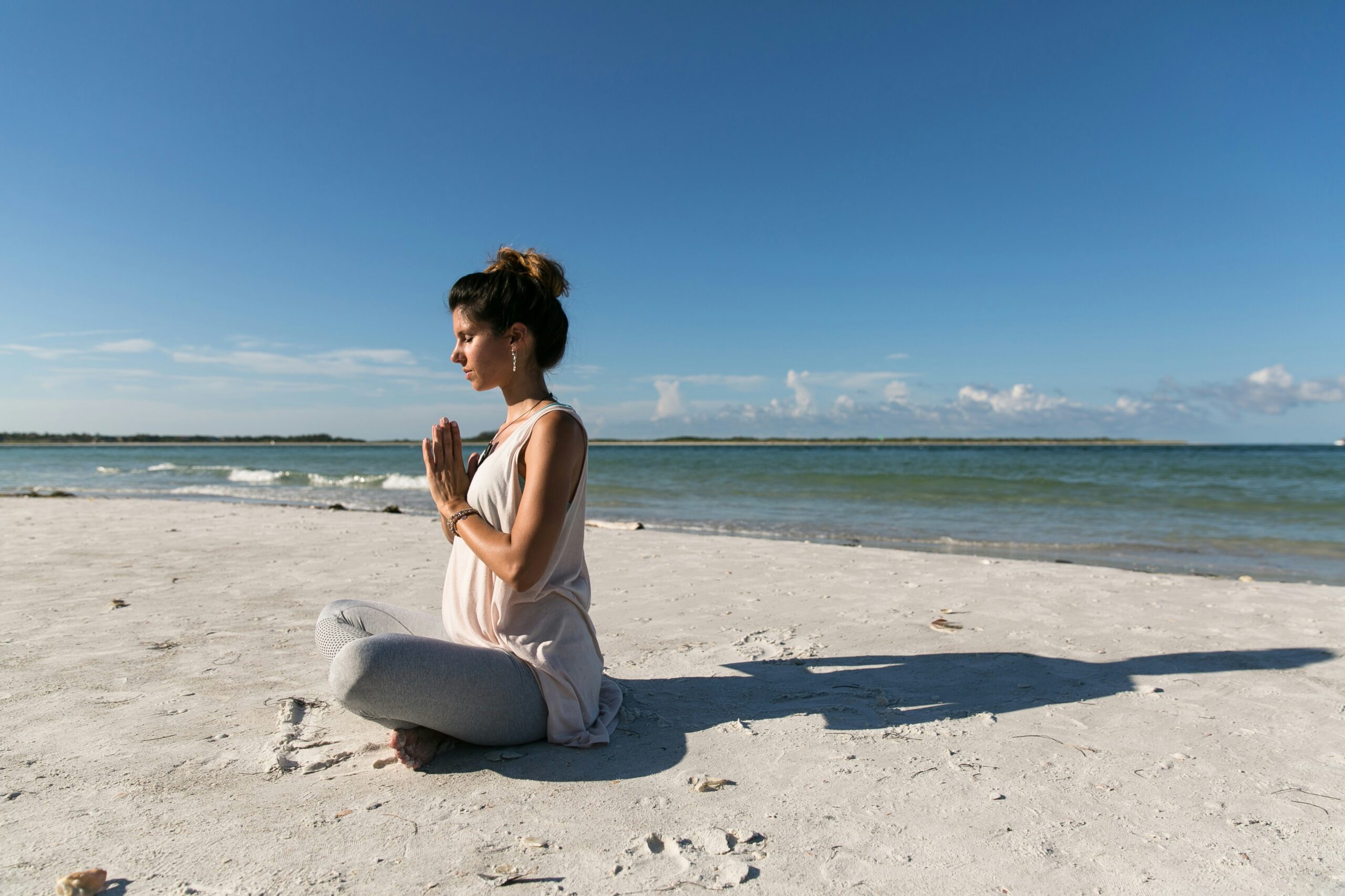 woman sitting cross-legged on the beach in yoga pose. don’t focus on communication