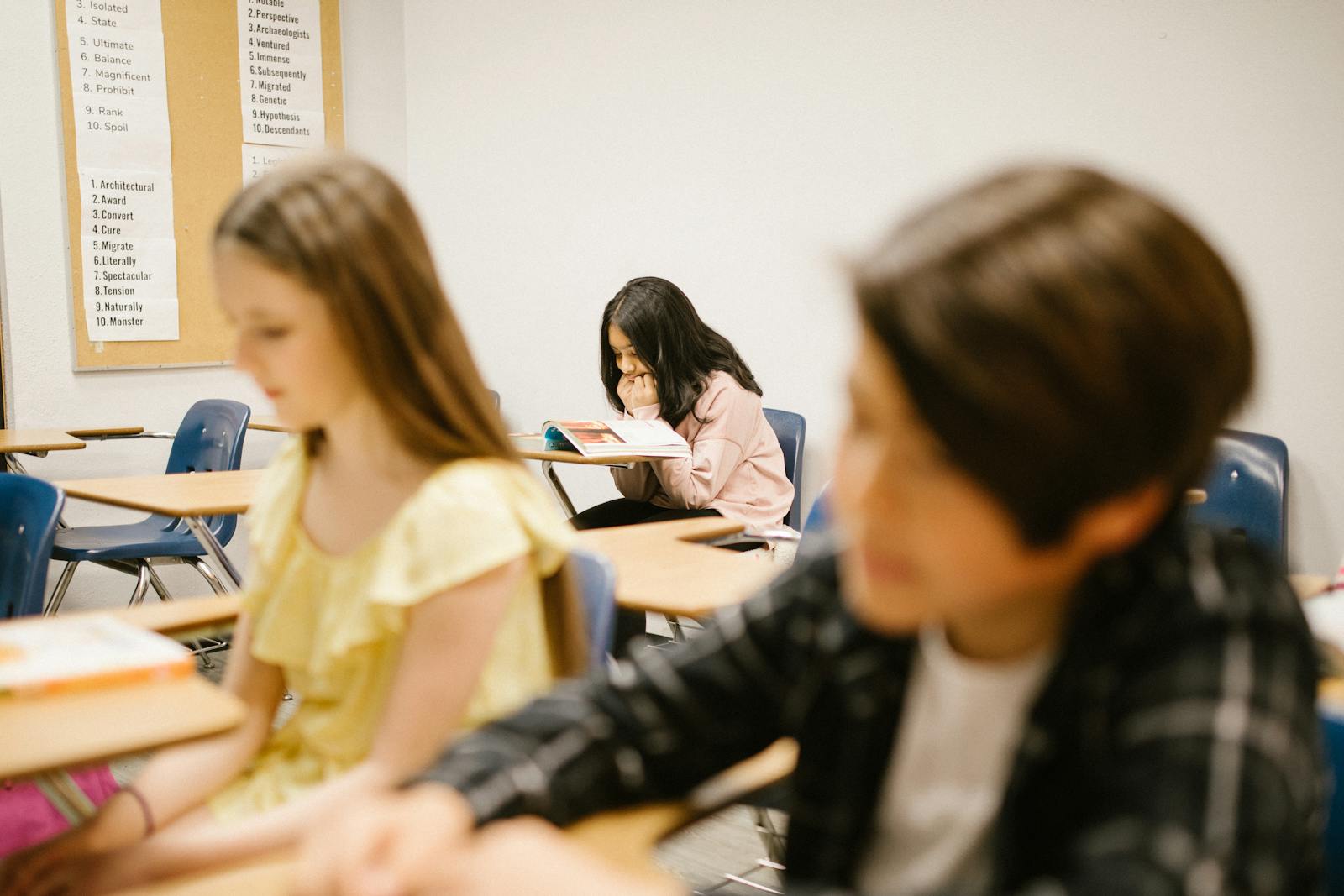 Young girl sitting lonely by herself in a classroom