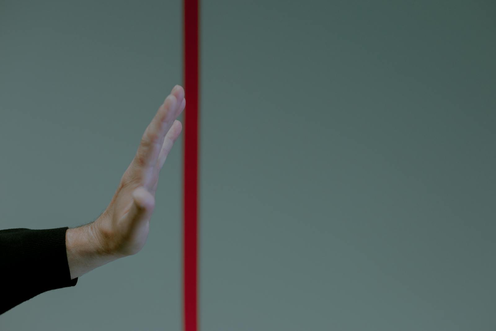 Hand behind red line depicting boundaries