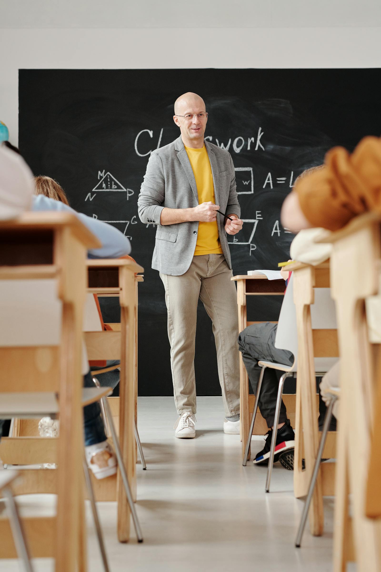 Teacher standing in front of a blackboard teaching lessons