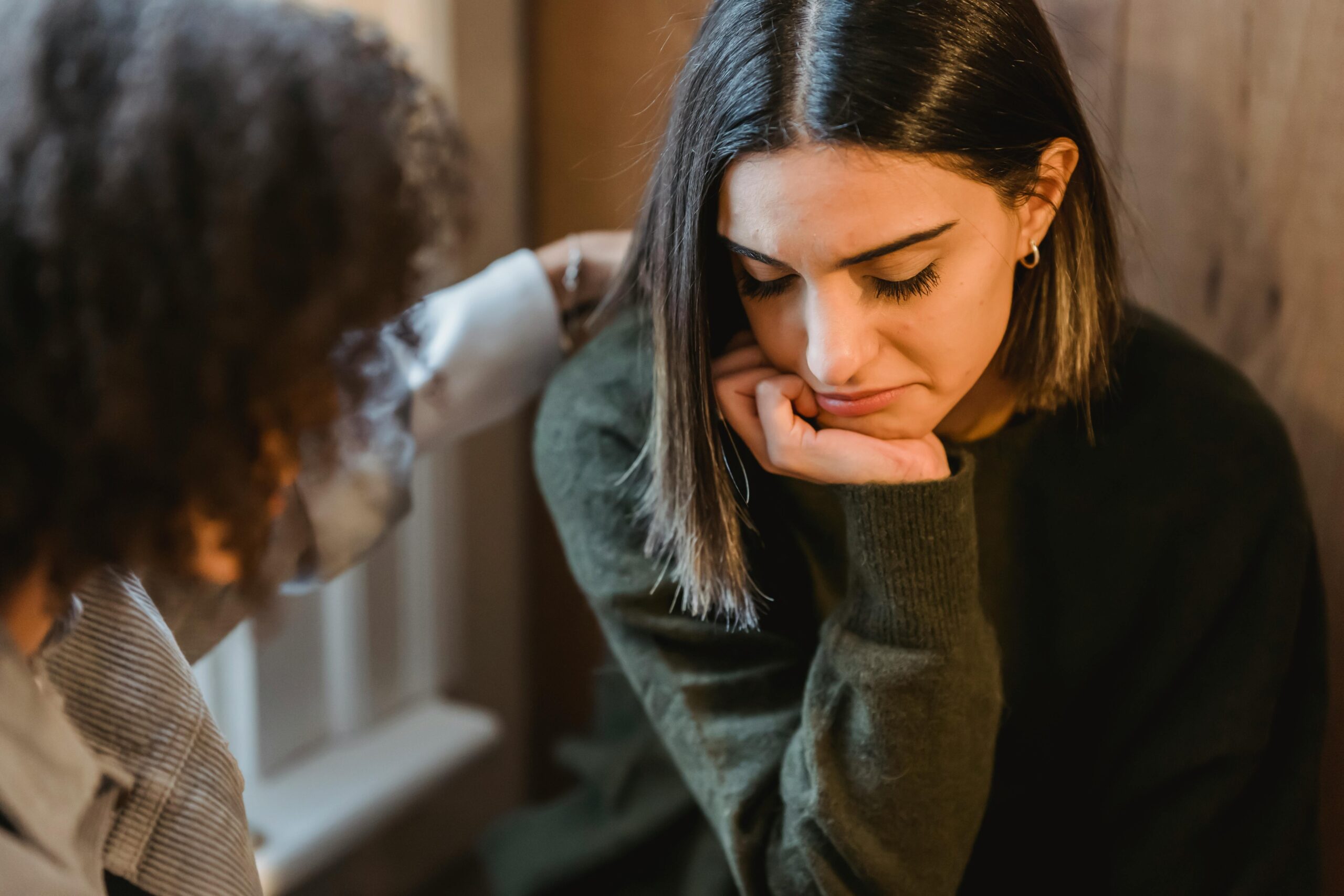 a distraught women is being consoled by a friend