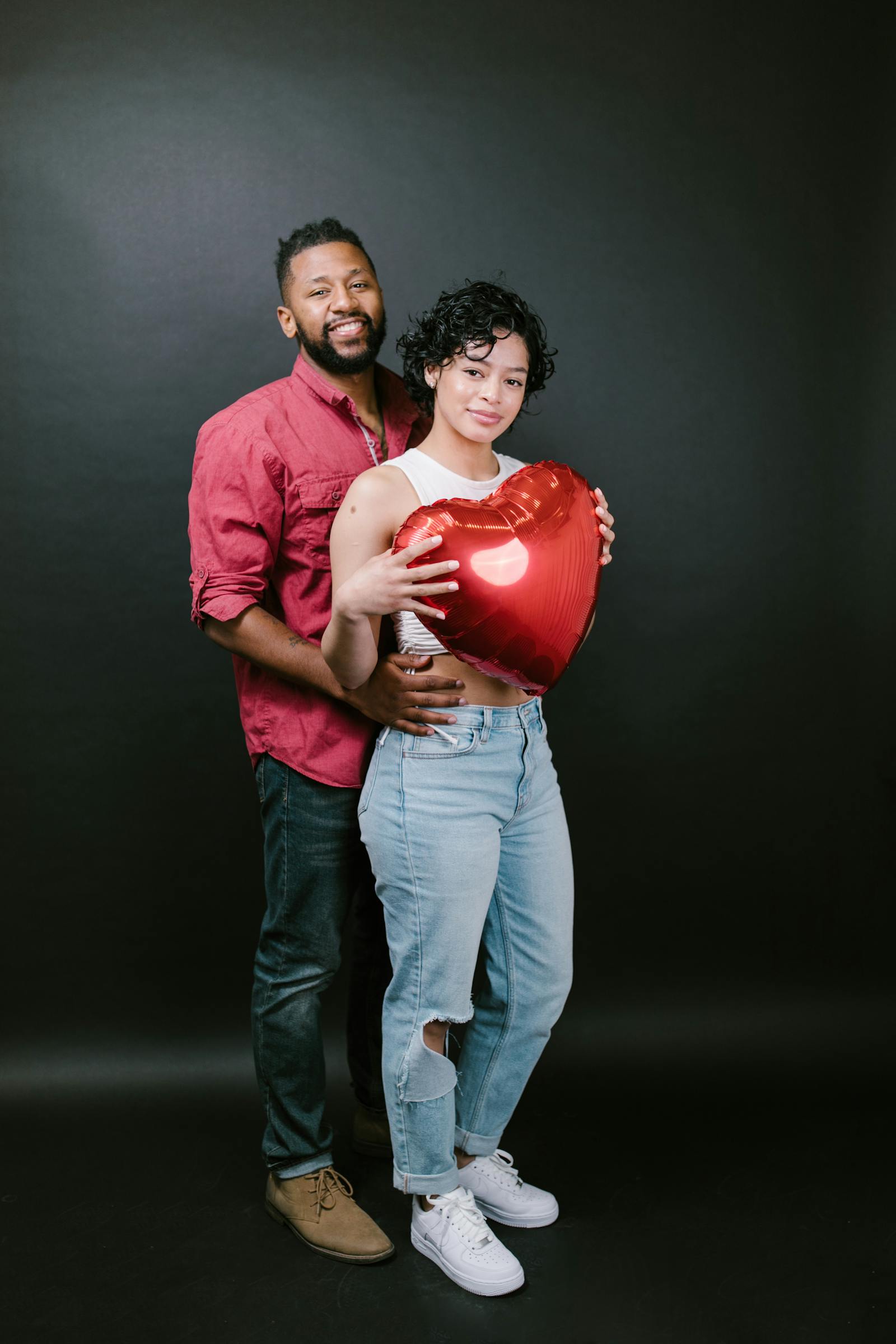 Couple holding red heart shaped balloon for Valentines Day