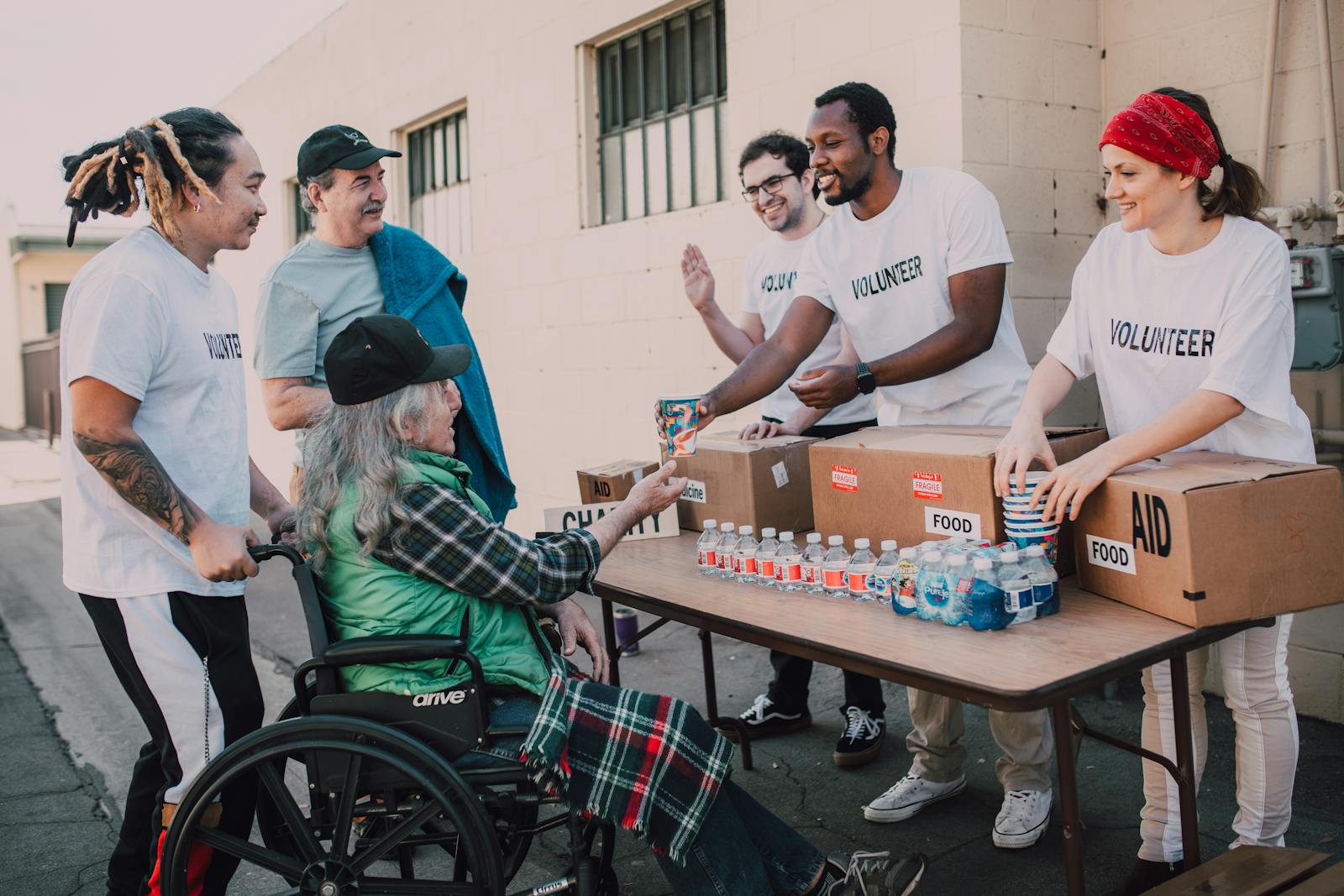 Volunteers helping elderly person showing kindness
