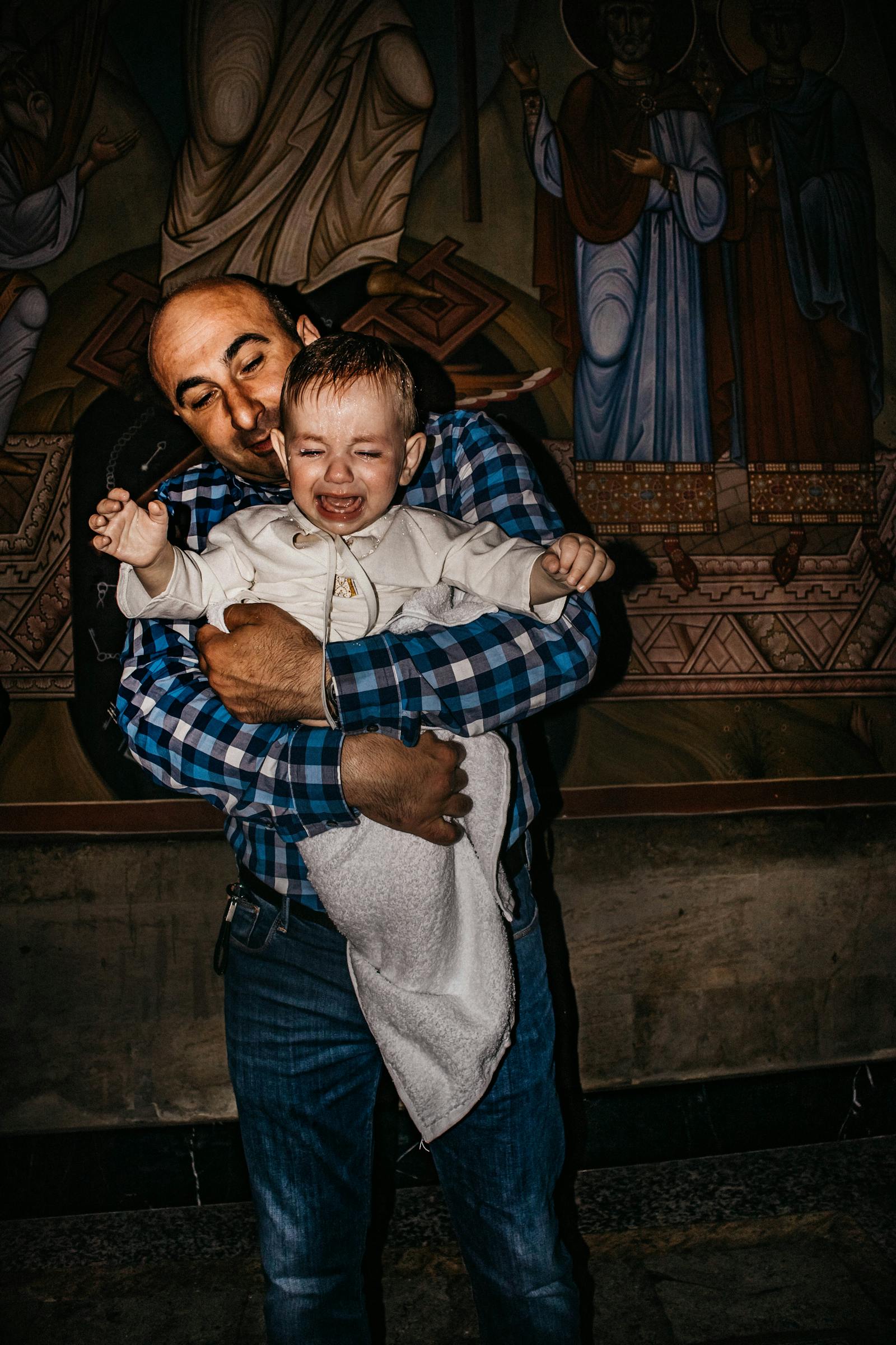 Unhappy father carrying his crying son