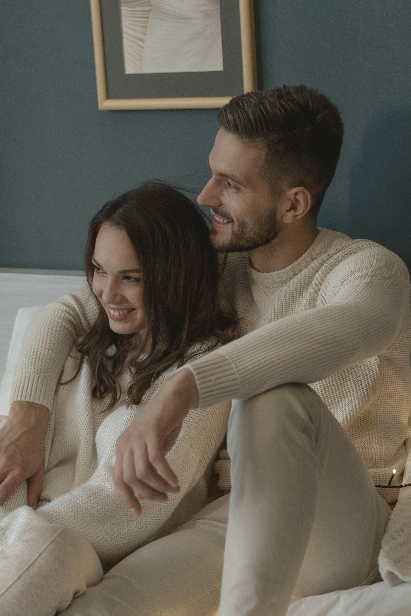 romantic couple sitting on bed next to each other exploring closeness vs codependency