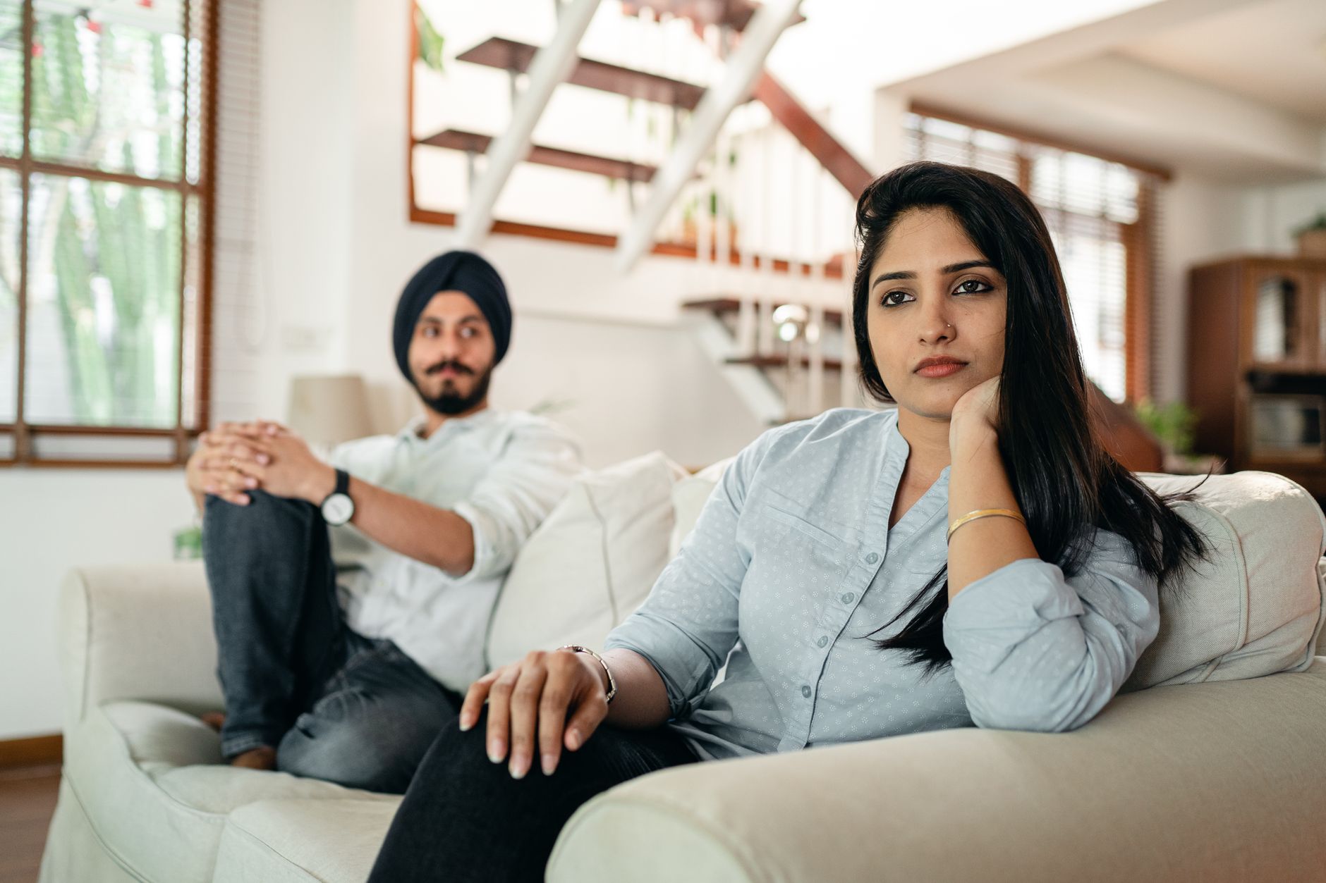 couple sitting apart on couch in silence