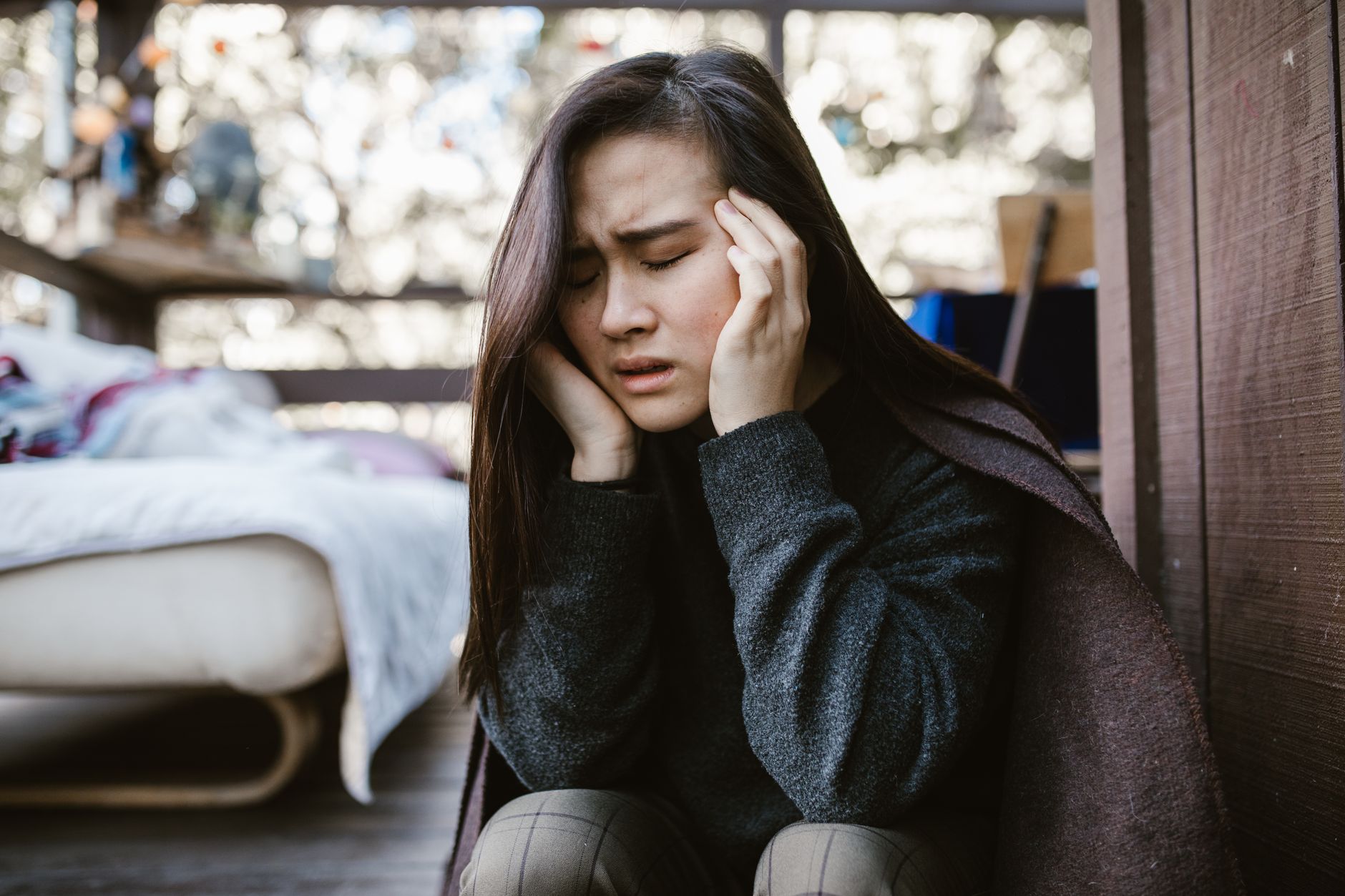 woman sitting quietly holding her chest in emotional pain